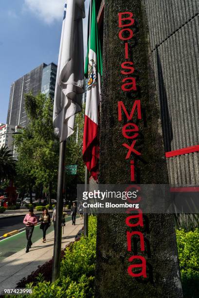 Pedestrians pass in front of the Bolsa Mexicana de Valores SAB, Mexico's stock exchange, in Mexico City, Mexico, on Friday, June 29, 2018. With just...
