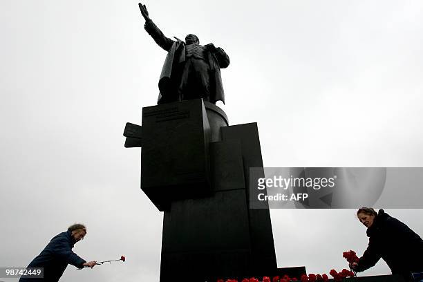 Russian communist supporters lay flowers near a statue to pay their respects to party founder Vladimir Lenin in St. Petersburg on April 22, 2010 on...
