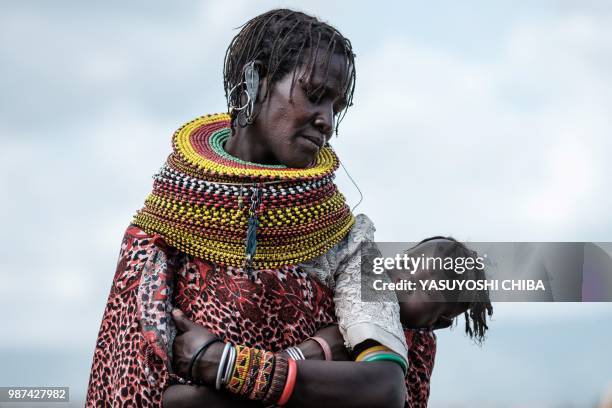 Woman of the Turkana tribe carries her child during the 11th Marsabit Lake Turkana Culture Festival in Loiyangalani near Lake Turkana, northern...