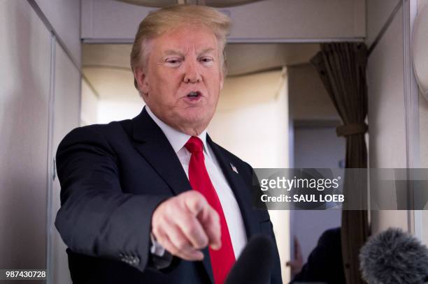 President Donald Trump speaks to the press aboard Air Force One in flight as he travels from Joint Base Andrews in Maryland, to Bedminster, New...