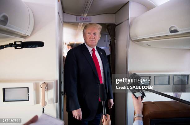 President Donald Trump speaks to the press aboard Air Force One in flight as he travels from Joint Base Andrews in Maryland, to Bedminster, New...