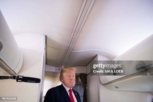 President Donald Trump speaks to the press aboard Air Force One in flight as he travels from Joint Base Andrews in Maryland, to Bedminster, New...