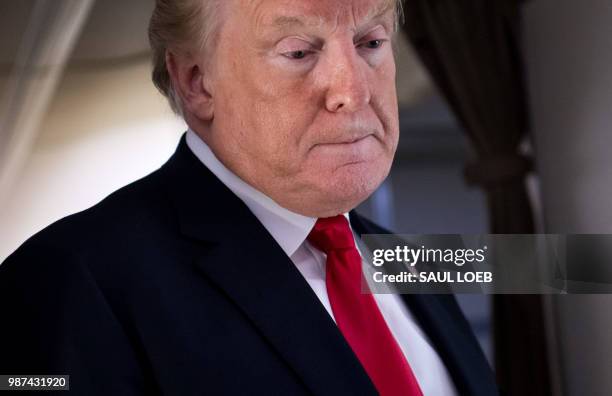 President Donald Trump speaks to the press aboard Air Force One in flight as he travels from Joint Base Andrews in Maryland, to Bedminster, New...