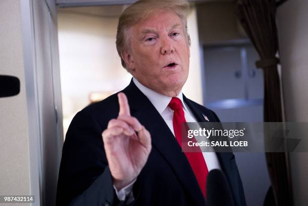 President Donald Trump speaks to the press aboard Air Force One in flight as he travels from Joint Base Andrews in Maryland, to Bedminster, New...