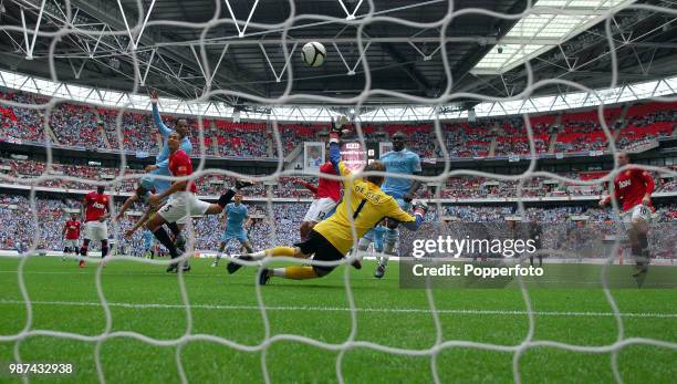 Joleon Lescott of Manchester City scores the first goal past David De Gea of Mancheseter United during the FA Community Shield match between...