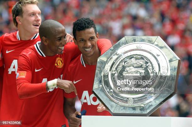 Man of the Match Nani of Manchester United celebrates with the trophy and teammates Phil Jones and Ashley Young following the FA Community Shield...