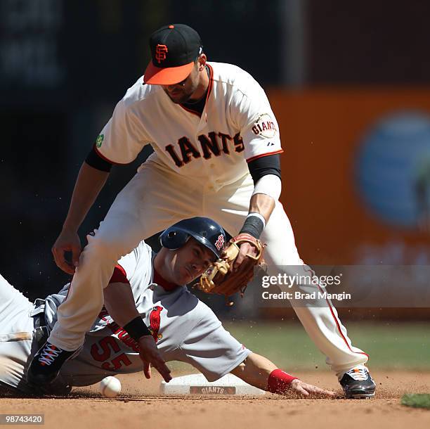 Skip Schumaker of the St. Louis Cardinals slides into second base safely as San Francisco Giants second baseman Mark DeRosa drops a throw during the...