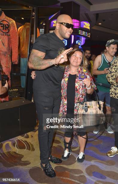 Rapper Flo Rida poses with a fan during his memorabilia case dedication at the Hard Rock Hotel & Casino on June 29, 2018 in Las Vegas, Nevada.