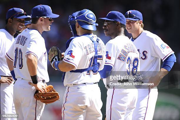 Manager Ron Washington of the Texas Rangers stands on the pitcher's mound as he waits for a relief pitcher along with Elvis Andrus, Andres Blanco ,...