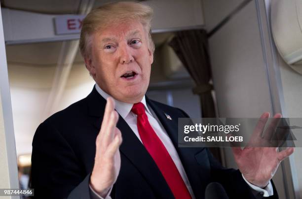 President Donald Trump speaks to the press aboard Air Force One in flight as he travels from Joint Base Andrews in Maryland, to Bedminster, New...