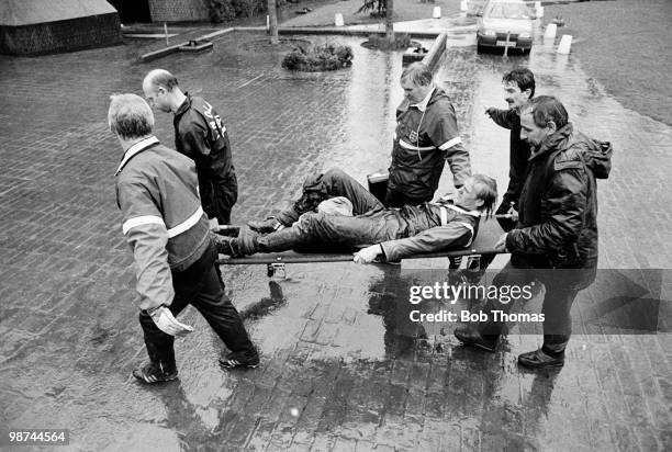 Gary Bailey of Manchester United and England is carried off the practice field following an injury during England football training at Bisham Abbey...