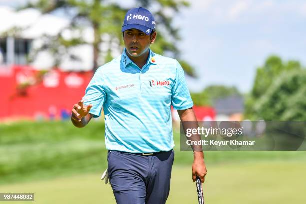 Anirban Lahiri of India celebrates and waves to fans after making a par putt on the 18th hole green during the second round of the Quicken Loans...