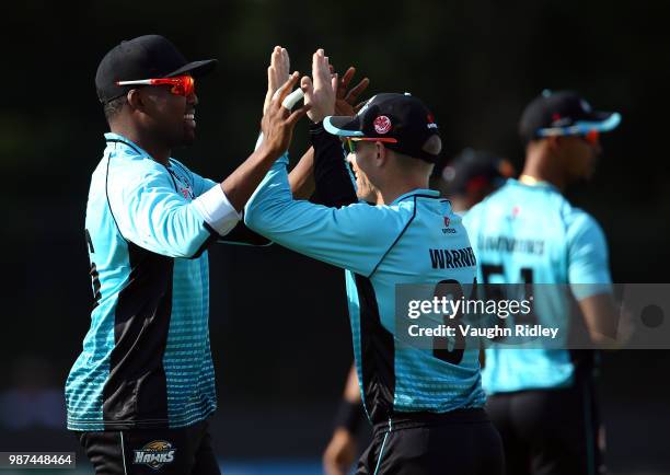 David Warner of Winnipeg Hawks celebrates with Darren Bravo after catching Dwayne Smith of Montreal Tigers out during a Global T20 Canada match at...