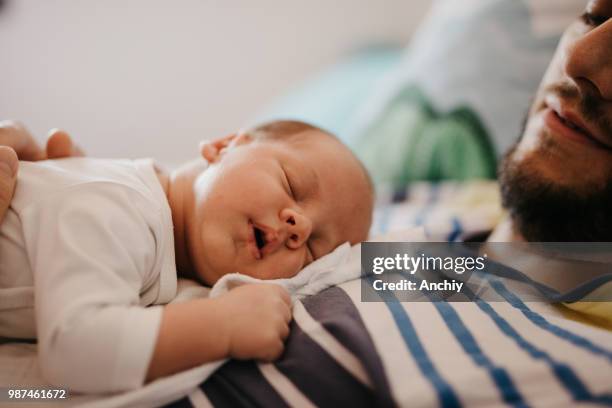 father and baby son sleeping in bedroom - cute baby sleeping stock pictures, royalty-free photos & images