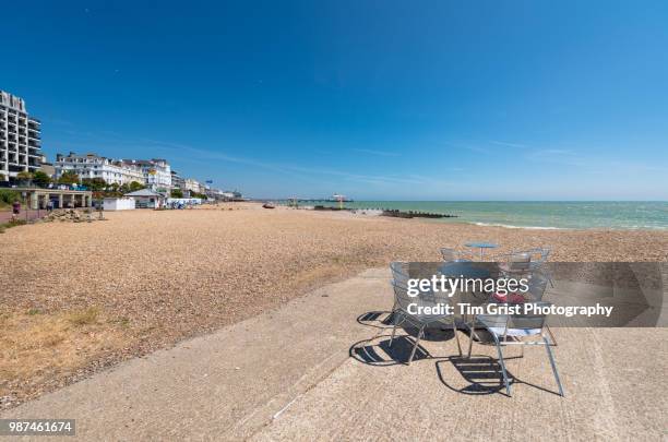 empty table and chairs, eastbourne seafront and eastbourne pier - eastbourne pier stockfoto's en -beelden