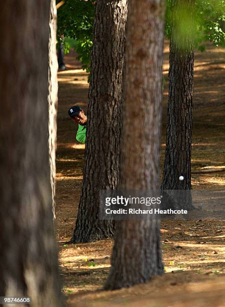 Tiger Woods plays from amoungst the trees on the 1st hole during the first round of the Quail Hollow Championship at Quail Hollow Country Club on...