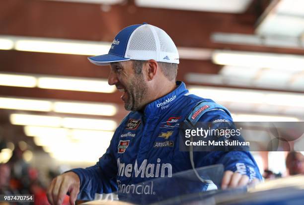 Elliott Sadler, driver of the OneMain Financial Chevrolet, stands in the garage area during practice for the NASCAR Xfinity Series Overton's 300 at...