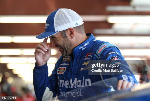 Elliott Sadler, driver of the OneMain Financial Chevrolet, stands in the garage area during practice for the NASCAR Xfinity Series Overton's 300 at...