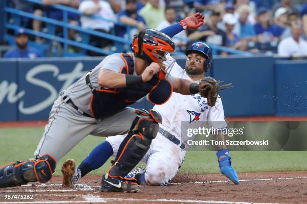 Kevin Pillar of the Toronto Blue Jays is forced out at home plate in the fourth inning during MLB game action as James McCann of the Detroit Tigers...