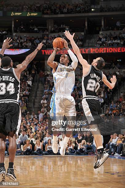 Smith of the Denver Nuggets takes a shot against Antonio McDyess and Manu Ginobili of the San Antonio Spurs on April 10, 2010 at the Pepsi Center in...