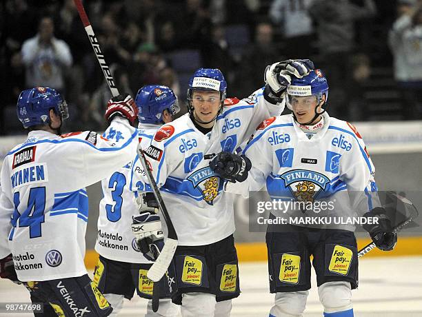 Sami Vatanen and Jussi Jokinen congratulate Mikael Grandlund after he scored the winning penalty past Russia's goalie Alexander Eremenko during their...