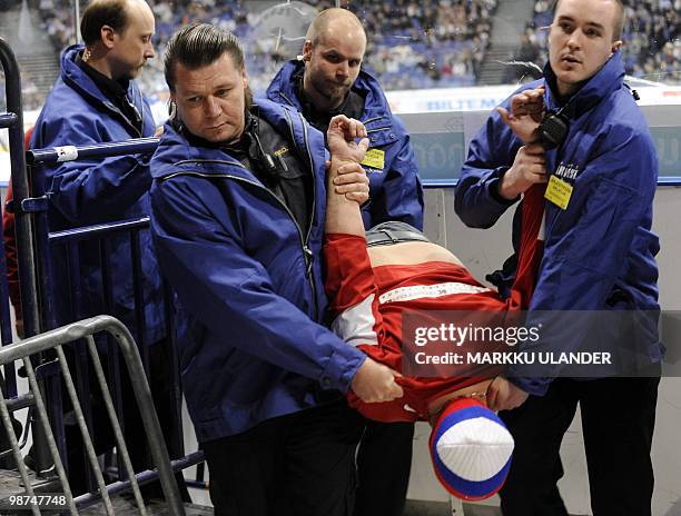 Russian spectator is carried out by security members from the the Euro Hockey Tour match Finland vs. Russia in Helsinki on April 29, 2010. AFP PHOTO/...