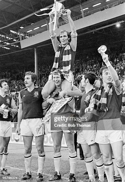 Aston Villa captain Ian Ross holding the trophy aloft whilst sitting on the shoulders of goalkeeper Jim Cumbes after their 1-0 victory over Norwich...