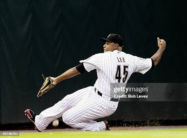 Left fielder Carlos Lee of the Houston Astros makes a sliding attempt on a fly ball down the line but comes up short during a game against the...