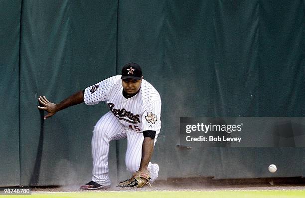 Left fielder Carlos Lee of the Houston Astros makes a sliding attempt on a fly ball down the line but comes up short during a game against the...