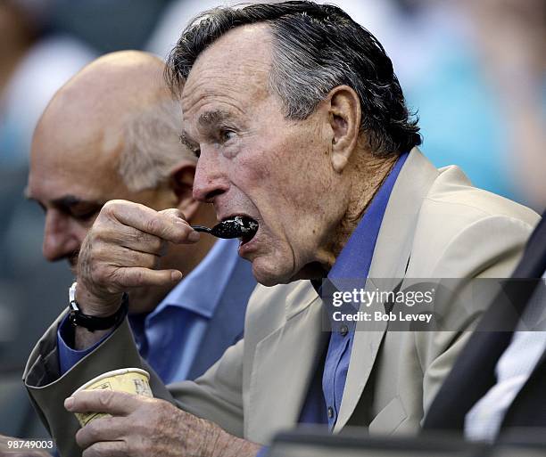 Former President George H.W. Bush enjoys some Borden ice cream as he watches the Cincinnati Reds play the Houston Astros at Minute Maid Park on April...