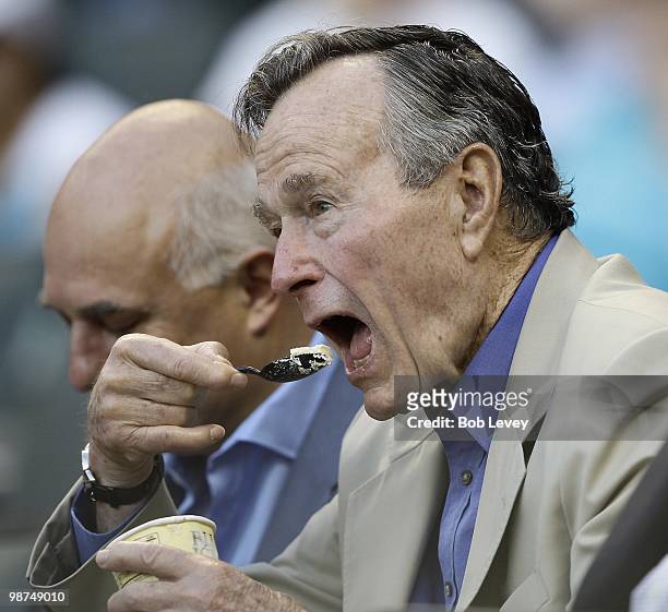 Former President George H.W. Bush enjoys some Borden ice cream as he watches the Cincinnati Reds play the Houston Astros at Minute Maid Park on April...