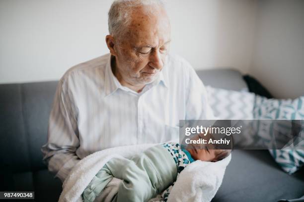 great-grandfather holding his  great grandson - great grandson stock pictures, royalty-free photos & images