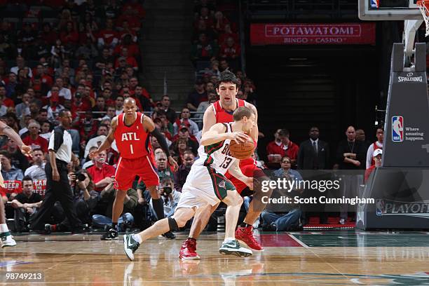 Luke Ridnour of the Milwaukee Bucks dribbles around the perimeter against Zaza Pachulia of the Atlanta Hawks in Game Three of the Eastern Conference...