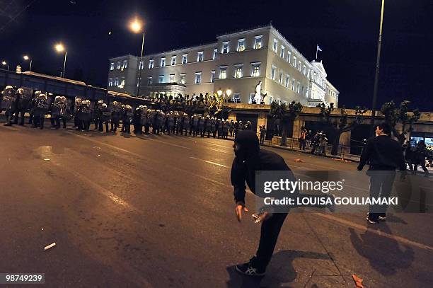 Protestors throw water bottles towards riot policemen protecting the greek parliament during a demonstration in Athens on April 29, 2010. Leftist...