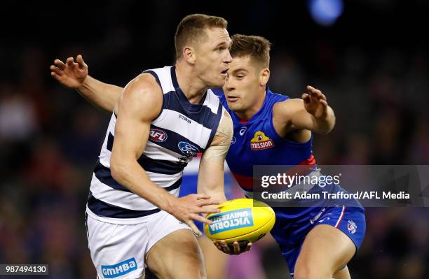 Joel Selwood of the Cats is tackled by Josh Dunkley of the Bulldogs during the 2018 AFL round 15 match between the Western Bulldogs and the Geelong...