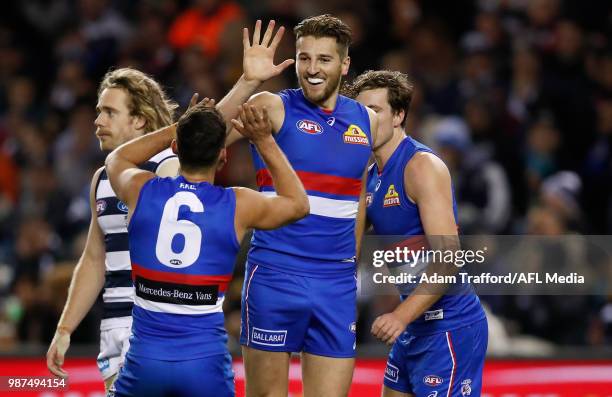 Marcus Bontempelli of the Bulldogs celebrates a goal with Luke Dahlhaus and Zaine Cordy of the Bulldogs during the 2018 AFL round 15 match between...