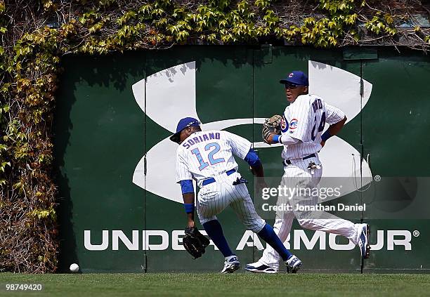 Alfonso Soriano of the Chicago Cubs, backed up by teammate Marlon Byrd, chases down a ball hit by Cole Gillespie of the Arizona Diamondbacks in the...