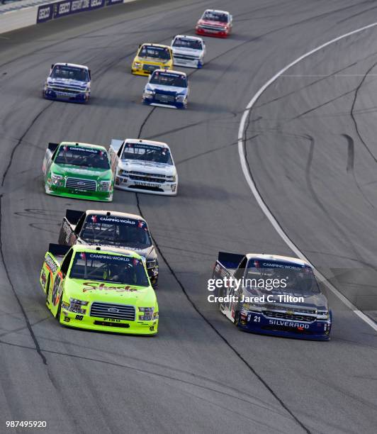 Matt Crafton, driver of the Shasta/Menards Ford, and Johnny Sauter, driver of the ISM Connect Chevrolet, lead a pack of trucks during the NASCAR...