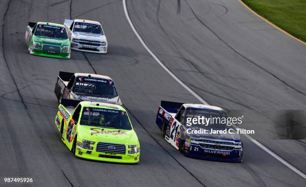Matt Crafton, driver of the Shasta/Menards Ford, and Johnny Sauter, driver of the ISM Connect Chevrolet, lead a pack of trucks during the NASCAR...