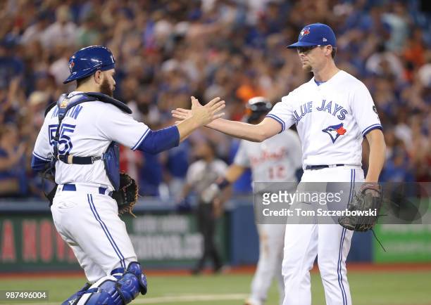 Tyler Clippard of the Toronto Blue Jays celebrates their victory with Russell Martin during MLB game action against the Detroit Tigers at Rogers...