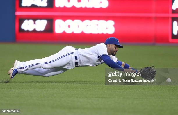 Devon Travis of the Toronto Blue Jays dives but cannot come up with a single by Victor Martinez of the Detroit Tigers in the seventh inning during...