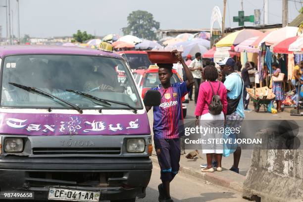 Young boy from Togo sells purified water at the taxi rank in Libreville on June 25, 2018. - Bought in West Africa, hundreds of child victims of...