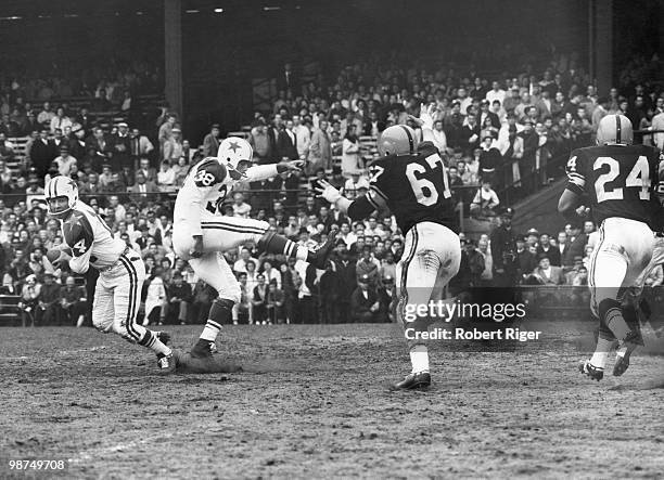 Eddie LeBaron of the Dallas Cowboys rolls out on a fake punt executed by Sam Baker against Bob Schmitz and Johnny Sample of the Pittsburgh Steelers...