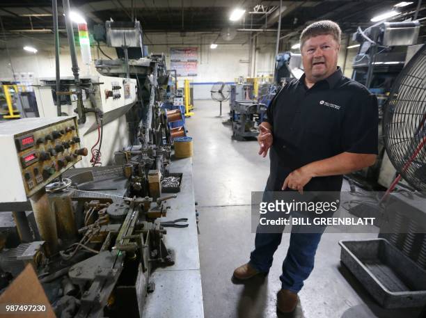 Mid Continent Nail Corporation CFO Chris Pratt, stands next to an ideled machine after customers have stopped placing orders in favor of cheaper...