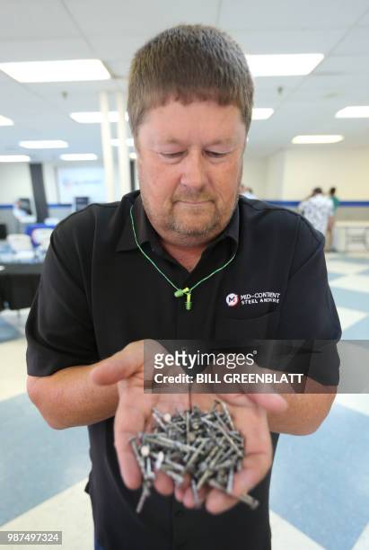 Mid Continent Nail Corporation's CFO Chris Pratt, displays some of the nails that customers have stopped placing orders for in favor of cheaper...