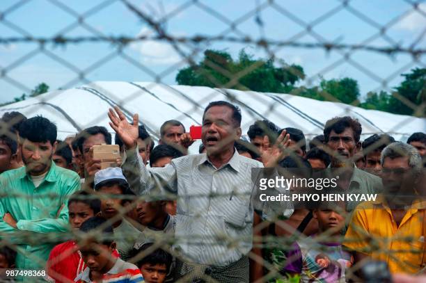 Rohingya refugees gather near the fence in the "no man's land" between Myanmar and Bangladesh border as seen from Maungdaw, Rakhine state, on June...
