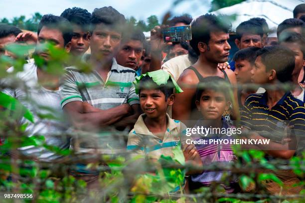 Rohingya refugees gather near the fence in the "no man's land" between Myanmar and Bangladesh border as seen from Maungdaw, Rakhine state, on June...