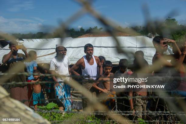 Rohingya refugees gather near the fence in the "no man's land" between Myanmar and Bangladesh border as seen from Maungdaw, Rakhine state, on June...