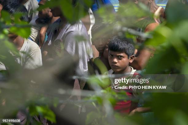 Rohingya refugees gather near the fence in the "no man's land" between Myanmar and Bangladesh border as seen from Maungdaw, Rakhine state, on June...