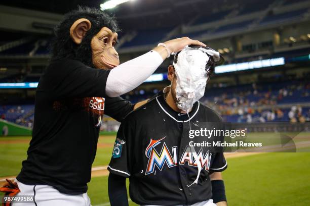 Riddle of the Miami Marlins is pied in the face by Miguel Rojas after they defeated the New York Mets 8-2 at Marlins Park on June 29, 2018 in Miami,...